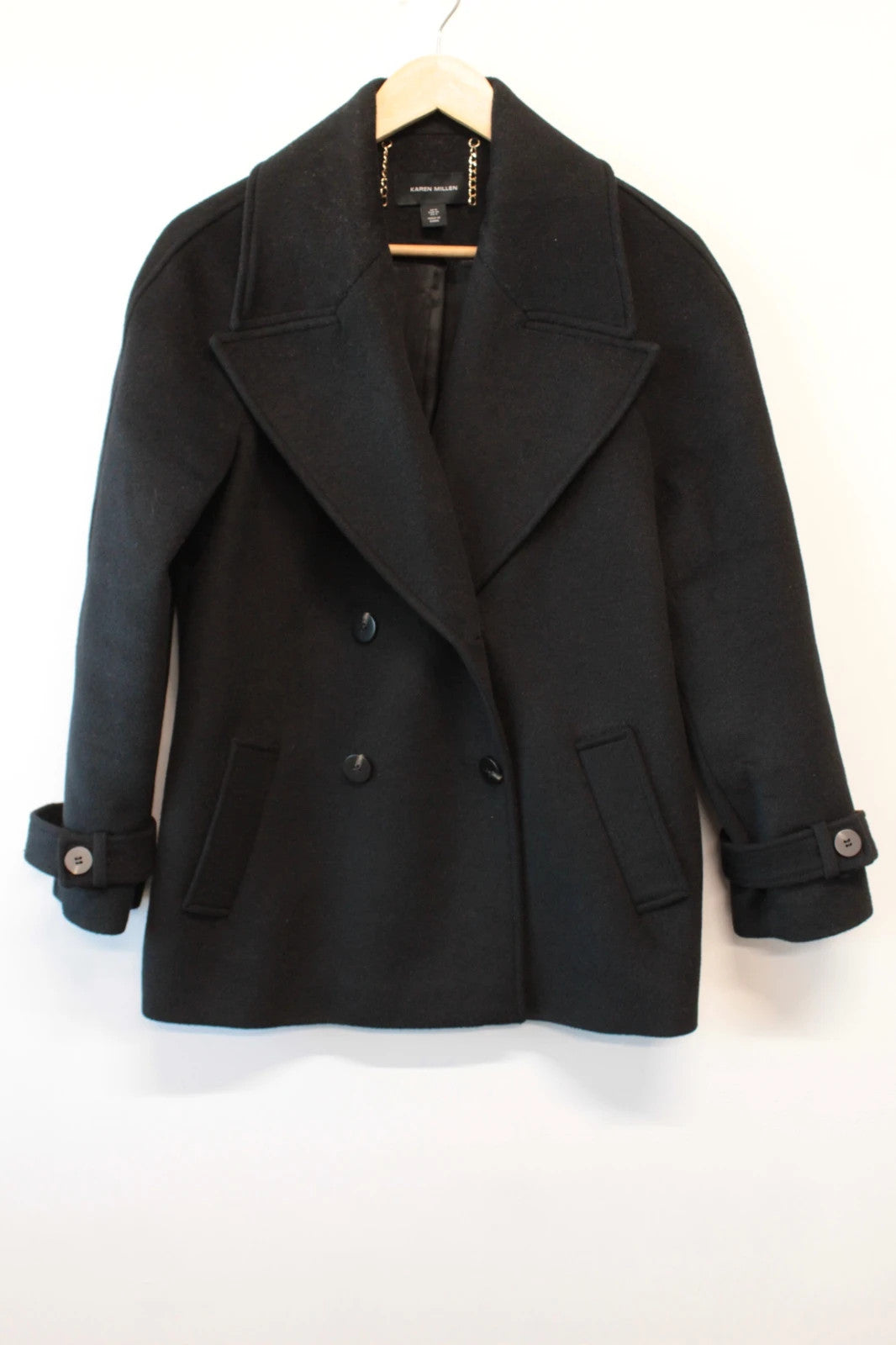 Karen Millen black double-breasted pea coat with tailored silhouette and gold hanging chain.