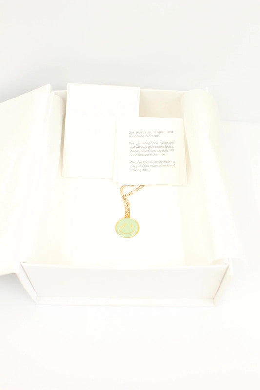 WE11DONE gold necklace with mint green enamel smile pendant on figaro chain.