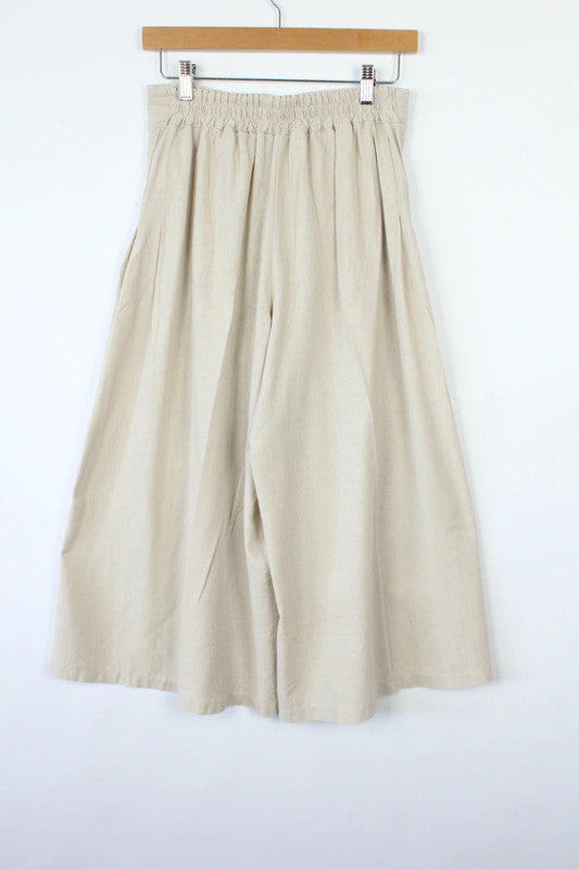 Vintage Dressing beige wide leg culottes with double-stacked wooden button waist closure.