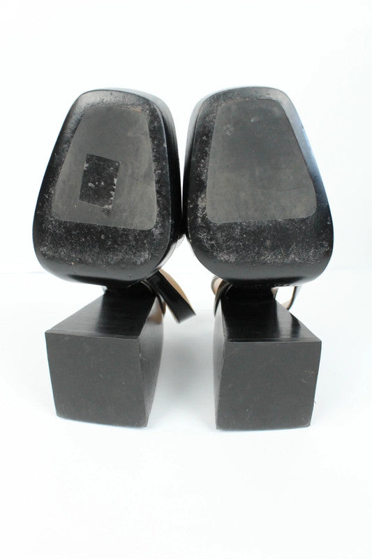 Nodaleto black patent leather slingback platform shoes with oversized square toe and block heel.