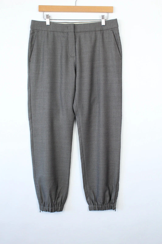 Max Mara grey wool trousers with cuffed ankles, slanted pockets, and subtle pleats.