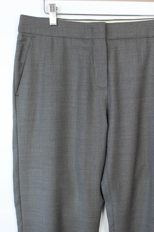 Max Mara grey wool trousers with cuffed ankles, slanted pockets, and subtle pleats.