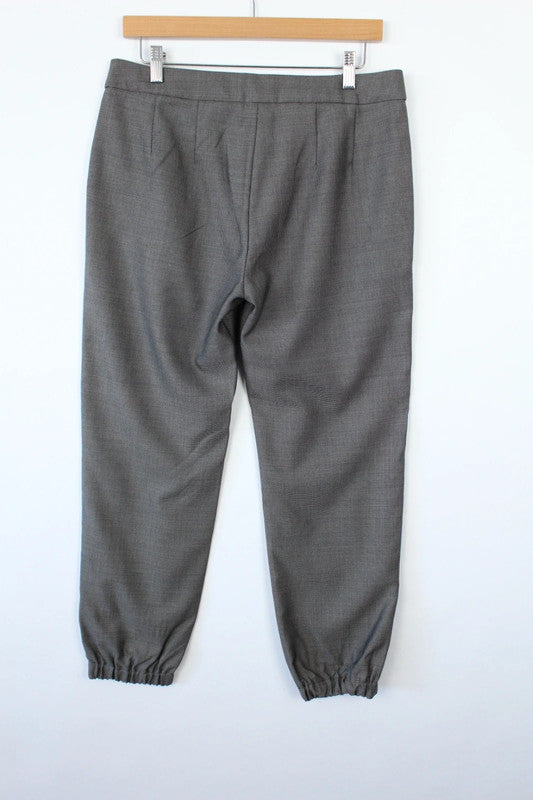 Max Mara grey wool trousers with cuffed ankles, slanted pockets, and subtle pleats.