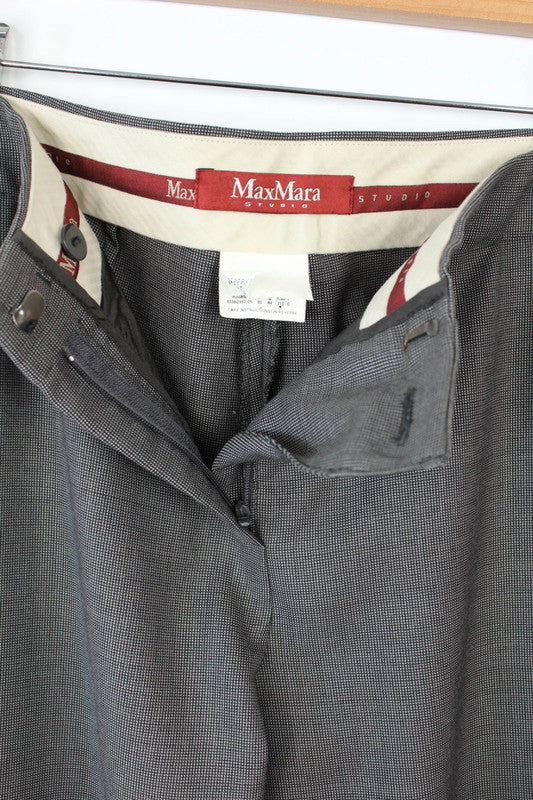 Max Mara grey wool trousers with cuffed ankles, slanted pockets, and subtle pleats.