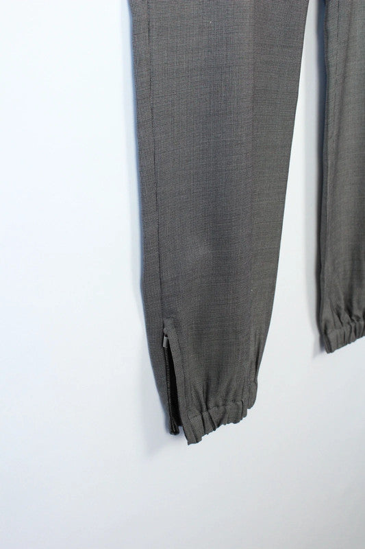 Max Mara grey wool trousers with cuffed ankles, slanted pockets, and subtle pleats.