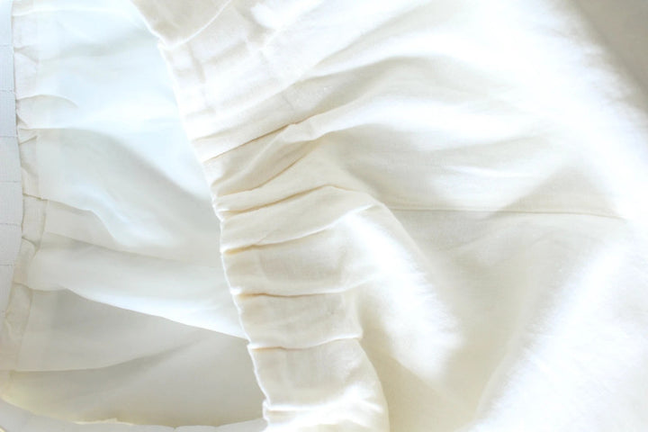 Vintage Dressing cream linen wide-leg culottes high-waisted, lightweight fabric, minimalist design.