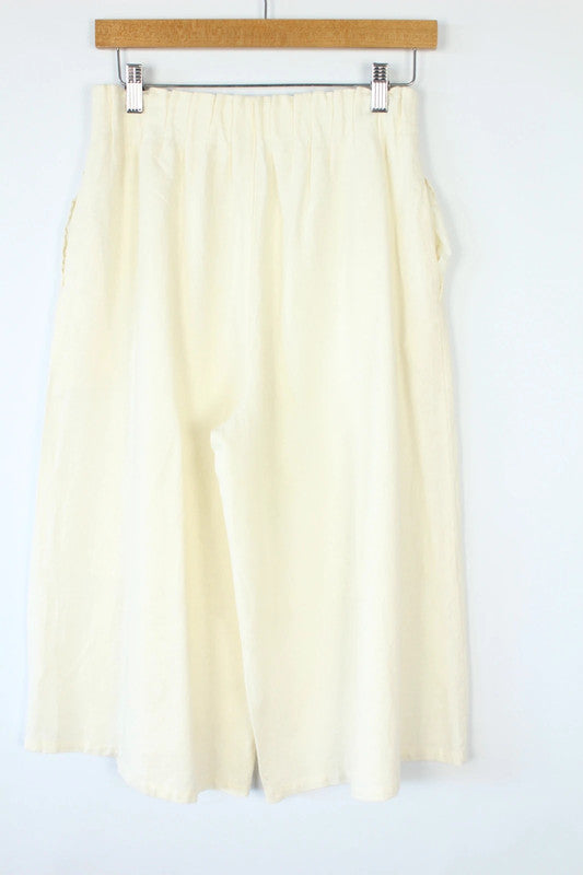 Vintage Dressing cream linen wide-leg culottes high-waisted, lightweight fabric, minimalist design.