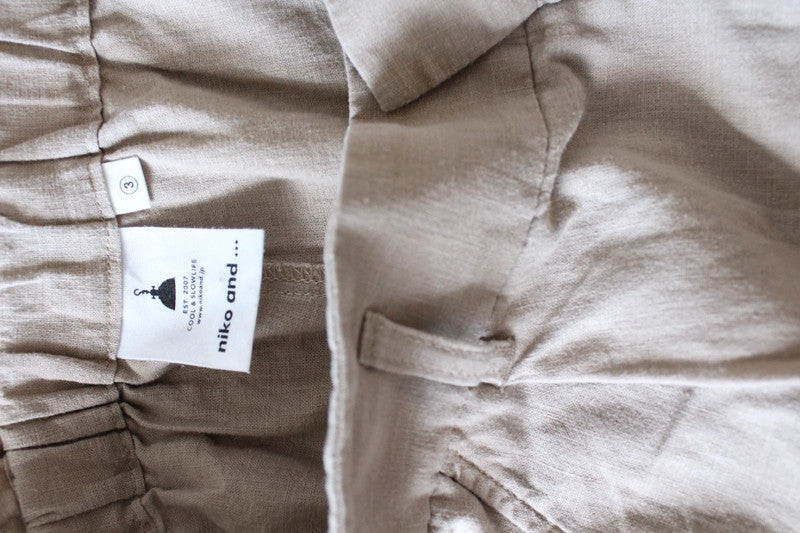 Niko and beige linen wide-leg culottes with high waist and minimalist design.