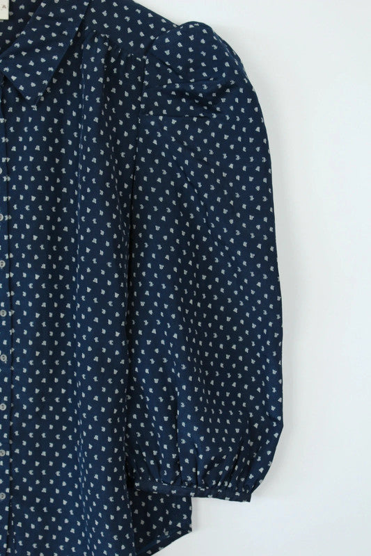 Vila navy blue puff sleeve blouse with white geometric print and button-down front.