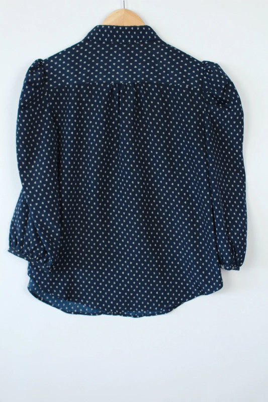 Vila navy blue puff sleeve blouse with white geometric print and button-down front.
