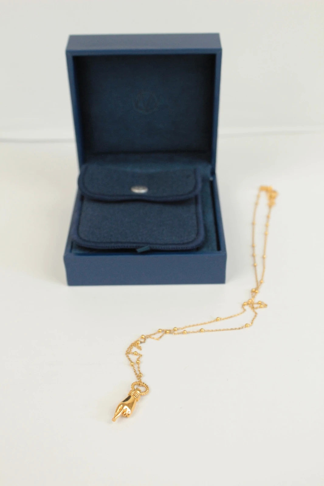Missoma gold necklace with Good Luck charm pendant and Orb chain design.