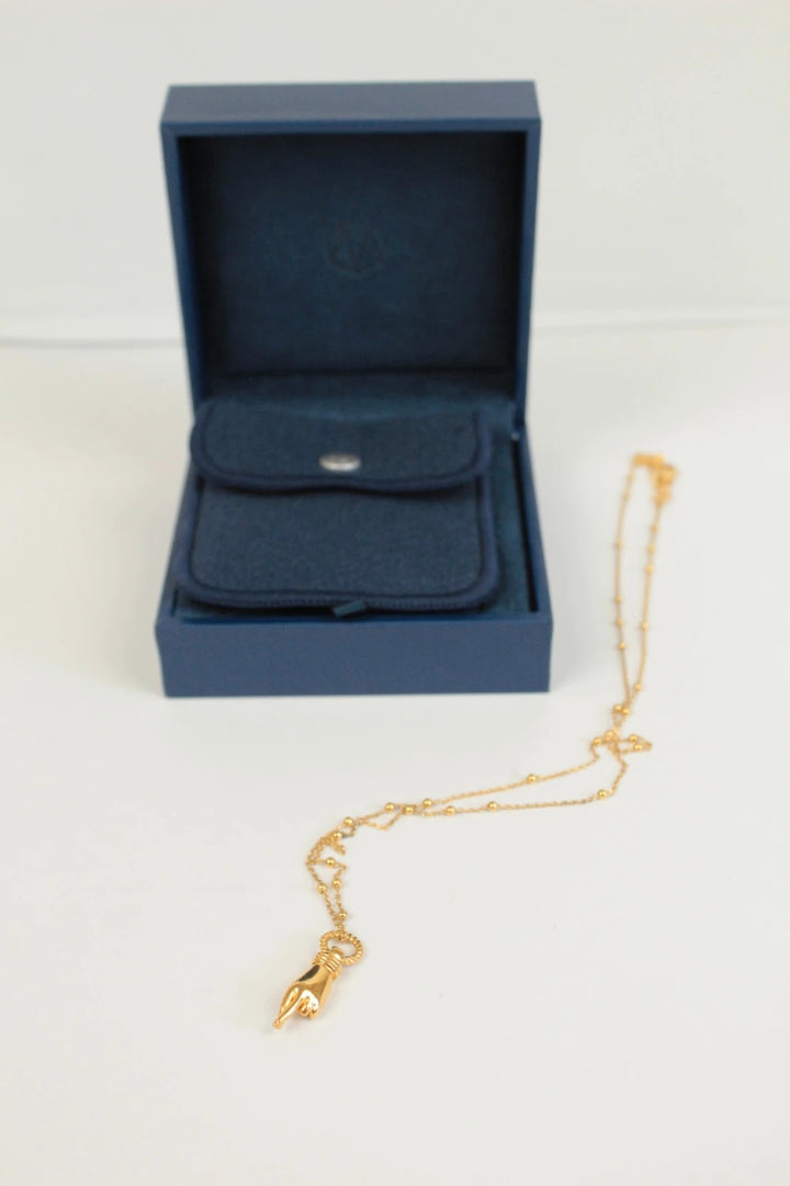 Missoma gold necklace with Good Luck charm pendant and Orb chain design.