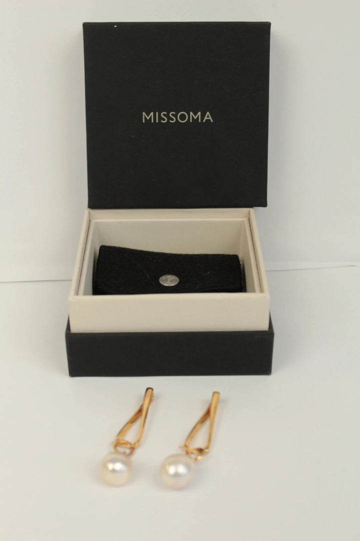 Missoma gold twisted drop earrings with baroque pearl and high-shine link hoop design.