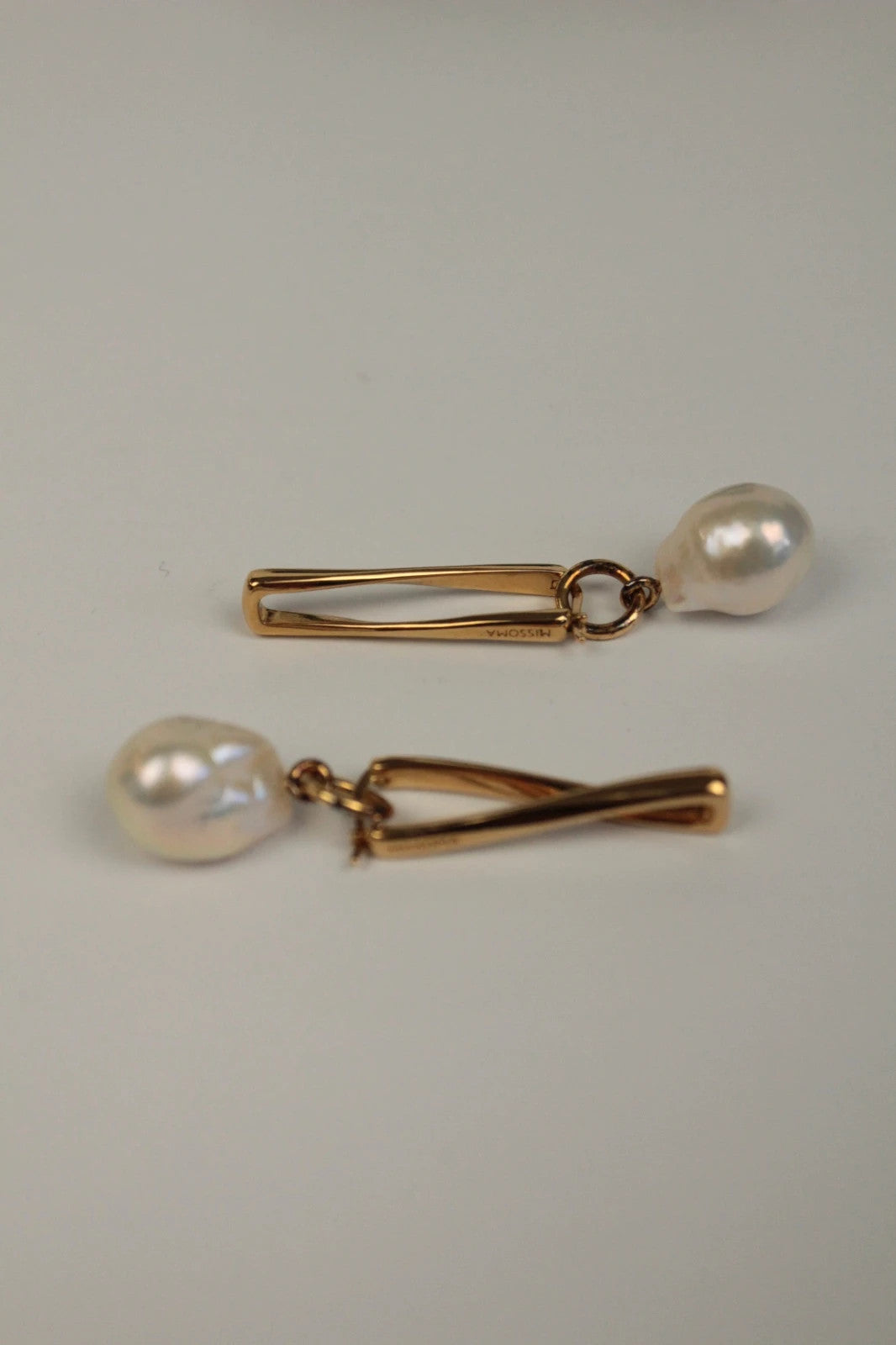 Missoma gold twisted drop earrings with baroque pearl and high-shine link hoop design.