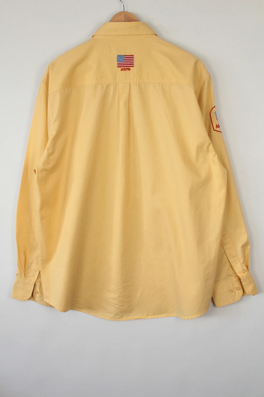 Vintage USA yellow Oxford shirt with embroidered American flag and retro patch on sleeve.