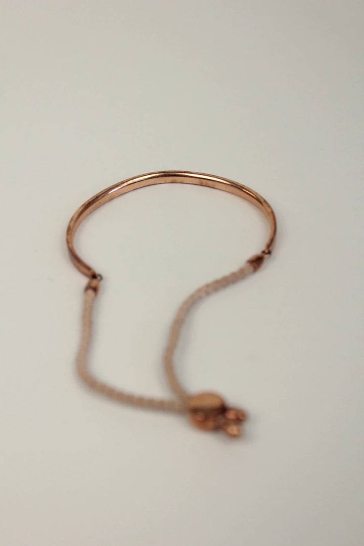 Joy stackable bracelet set rose gold tone with red and pink textile cords.