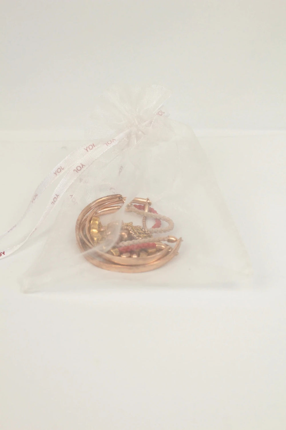 Joy stackable bracelet set rose gold tone with red and pink textile cords.