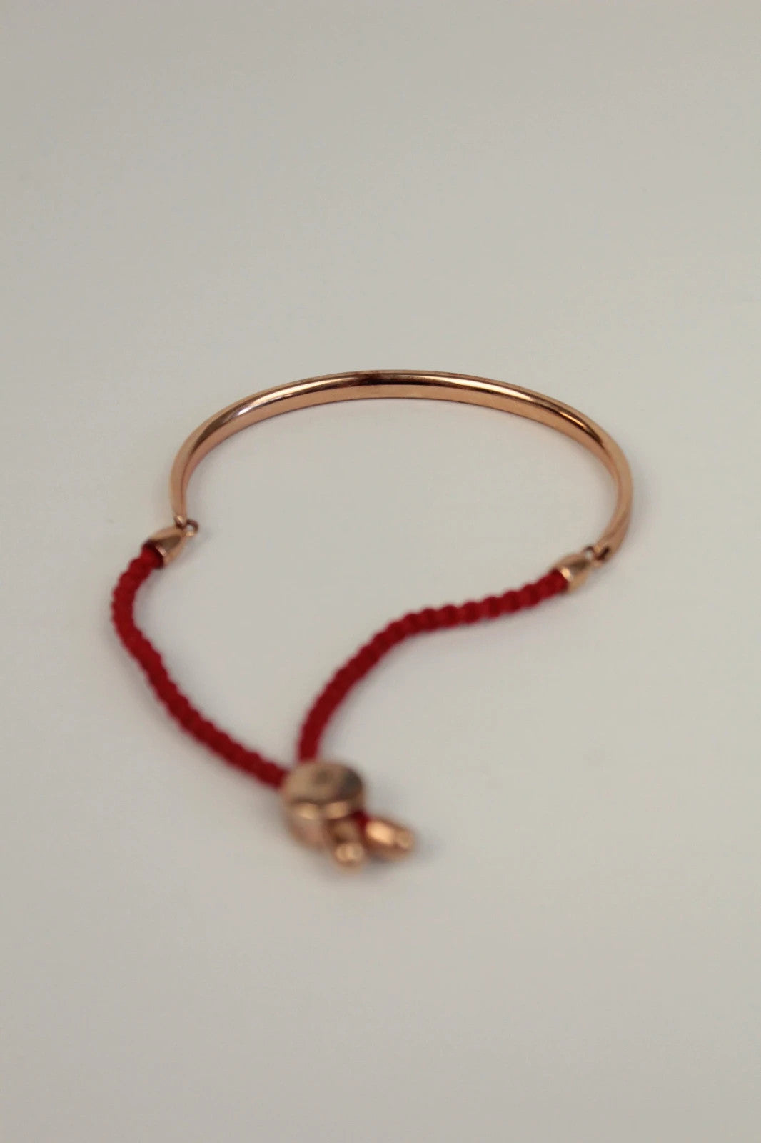 Joy stackable bracelet set rose gold tone with red and pink textile cords.