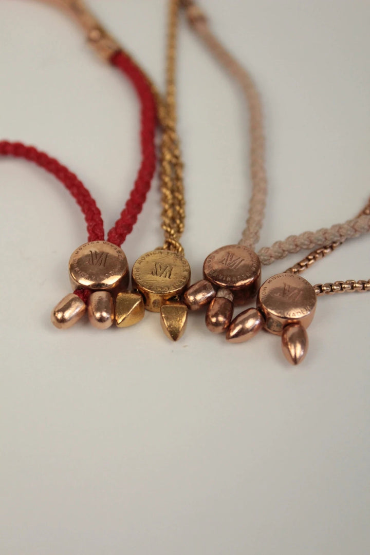 Joy stackable bracelet set rose gold tone with red and pink textile cords.