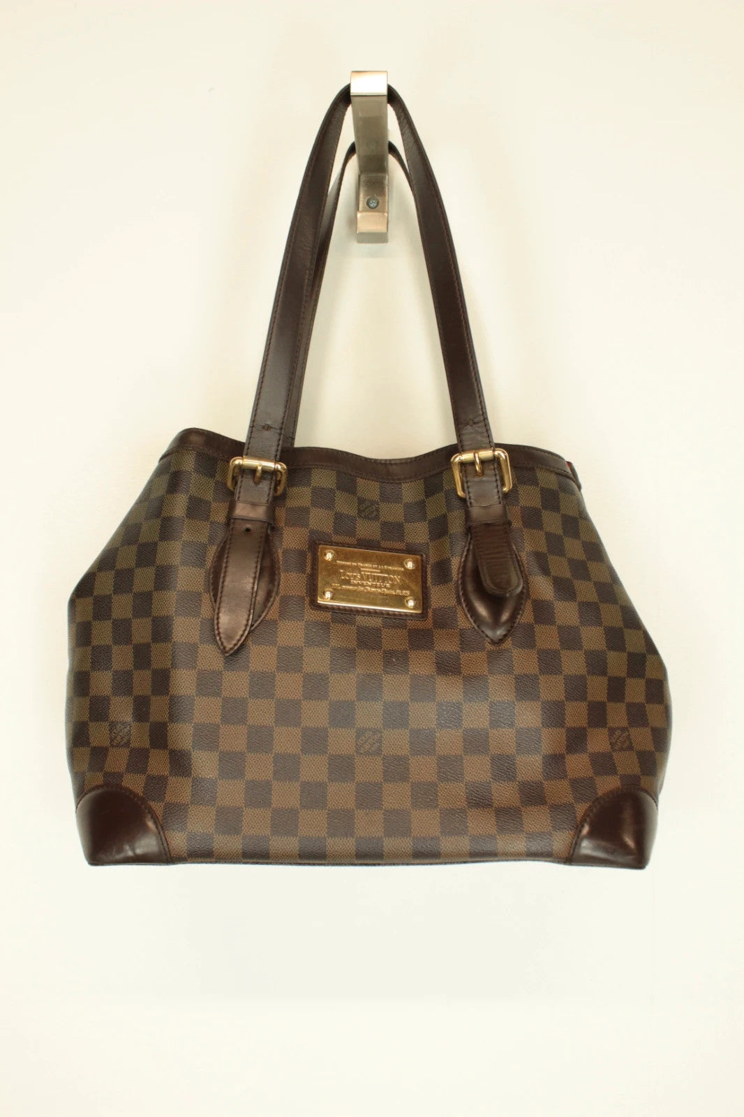 Louis Vuitton brown Hampstead tote bag with Damier Ebene pattern and leather handles.