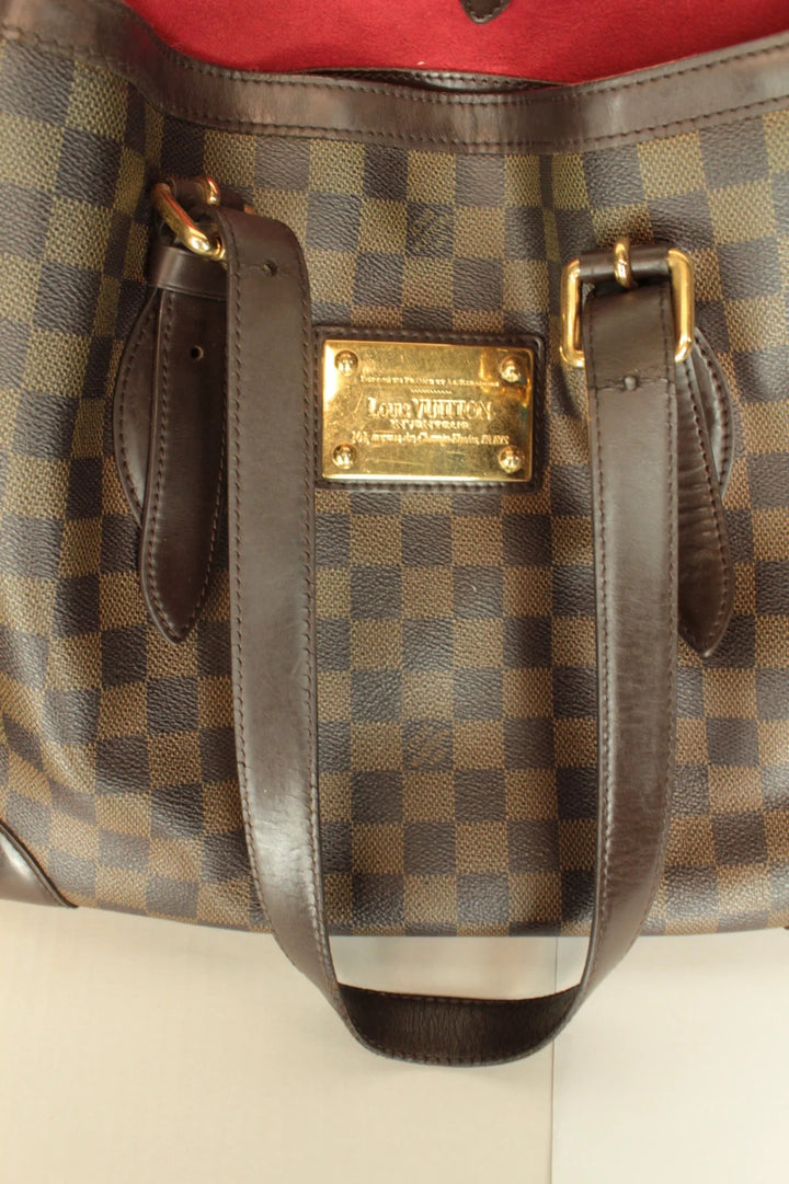 Louis Vuitton brown Hampstead tote bag with Damier Ebene pattern and leather handles.