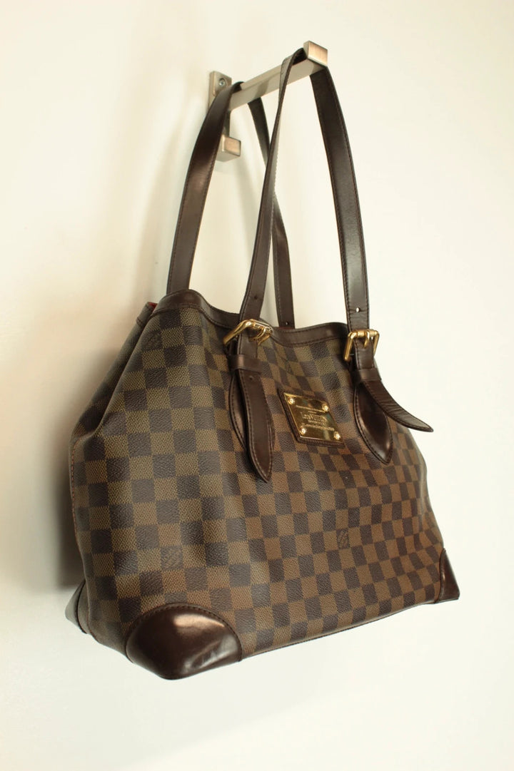Louis Vuitton brown Hampstead tote bag with Damier Ebene pattern and leather handles.