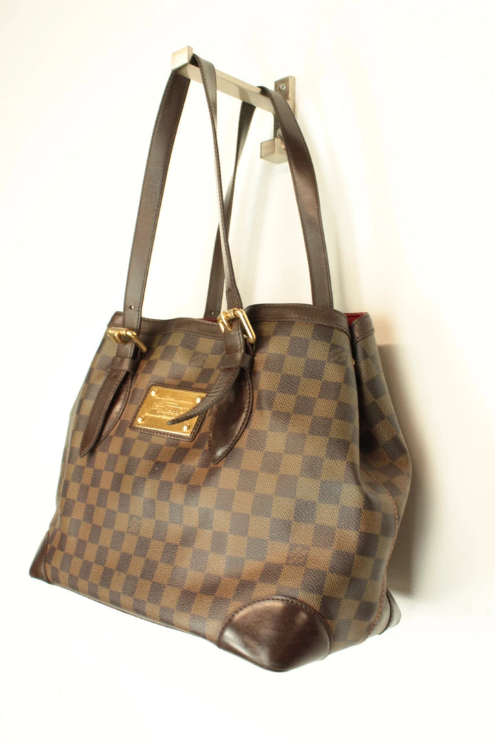 Louis Vuitton brown Hampstead tote bag with Damier Ebene pattern and leather handles.