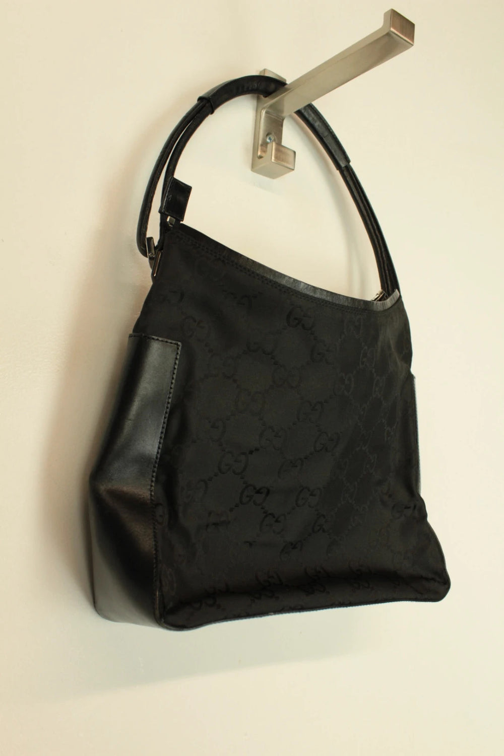 Gucci black hobo shoulder bag with GG monogram pattern and leather trim.