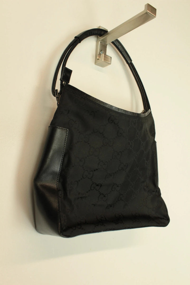 Gucci black hobo shoulder bag with GG monogram pattern and leather trim.