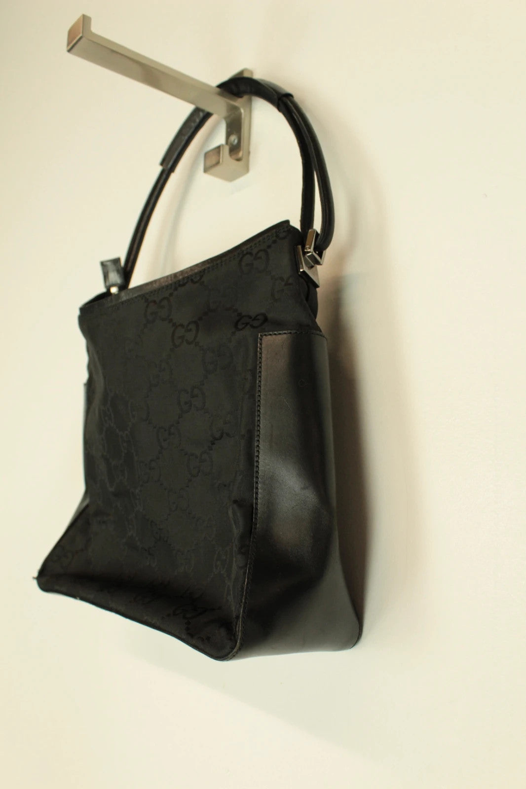 Gucci black hobo shoulder bag with GG monogram pattern and leather trim.