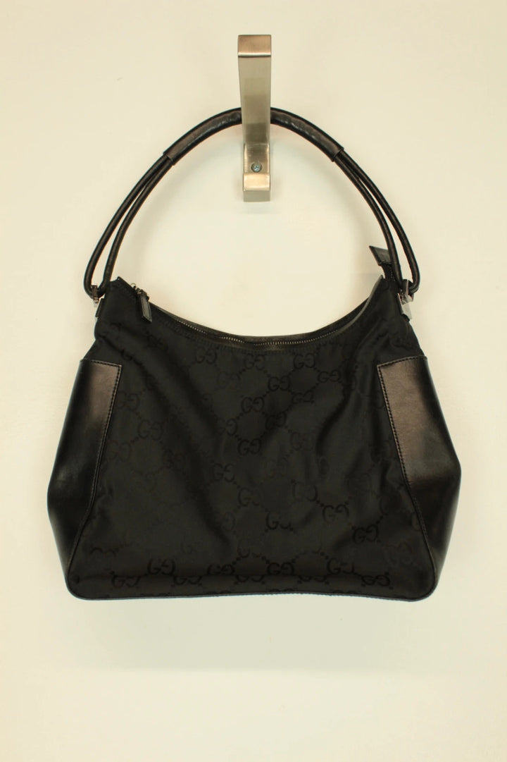 Gucci black hobo shoulder bag with GG monogram pattern and leather trim.