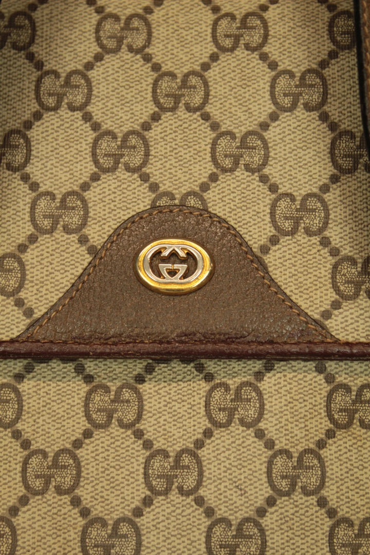Gucci beige GG Plus Supreme monogram handbag with brown leather trim and gold-tone emblem.