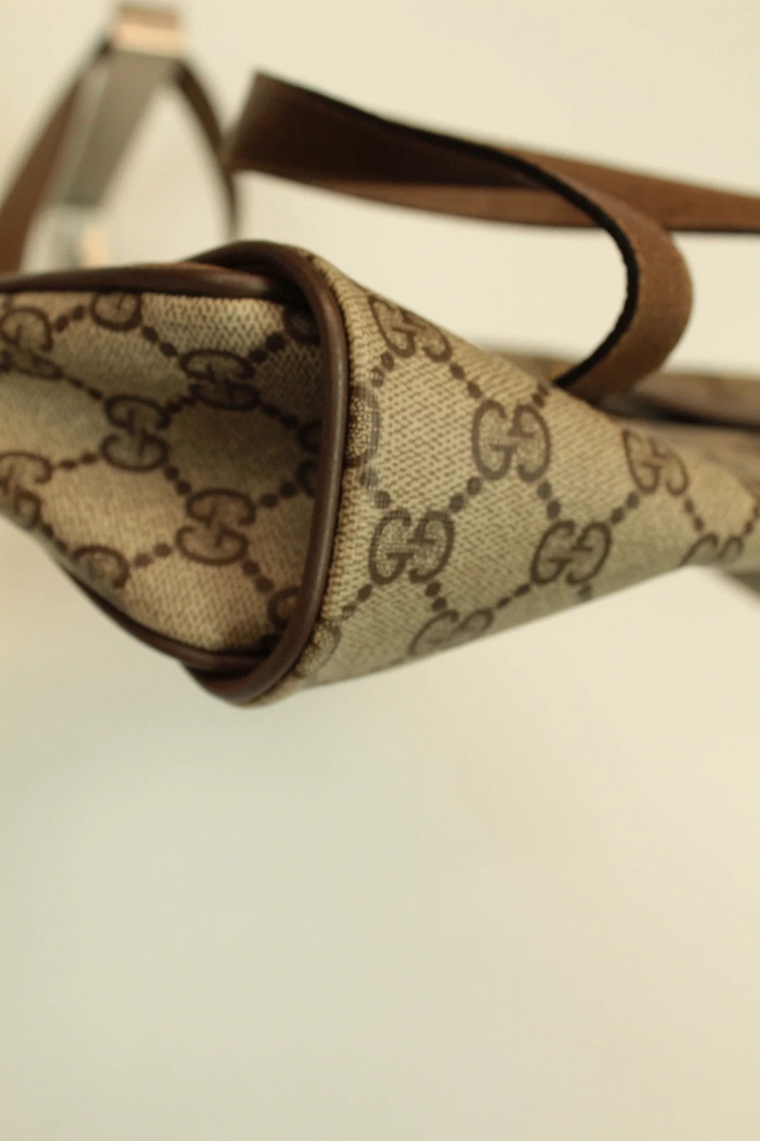 Gucci beige GG Plus Supreme monogram handbag with brown leather trim and gold-tone emblem.