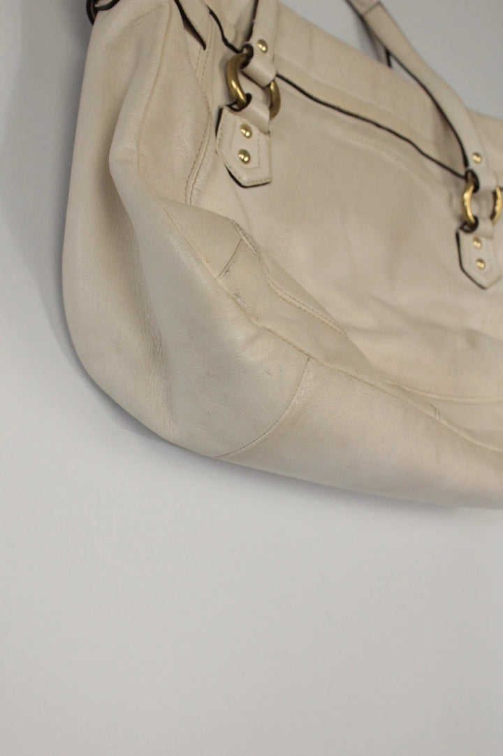 Coach cream leather satchel bag with gold-tone buckle clasp and matching hangtag.