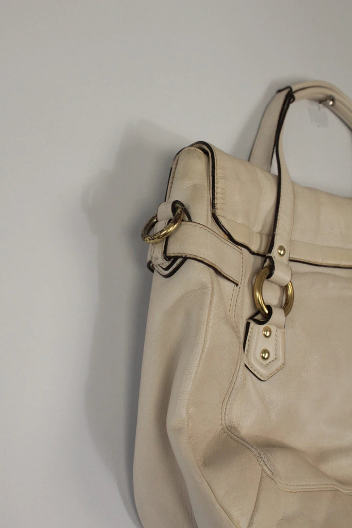 Coach cream leather satchel bag with gold-tone buckle clasp and matching hangtag.