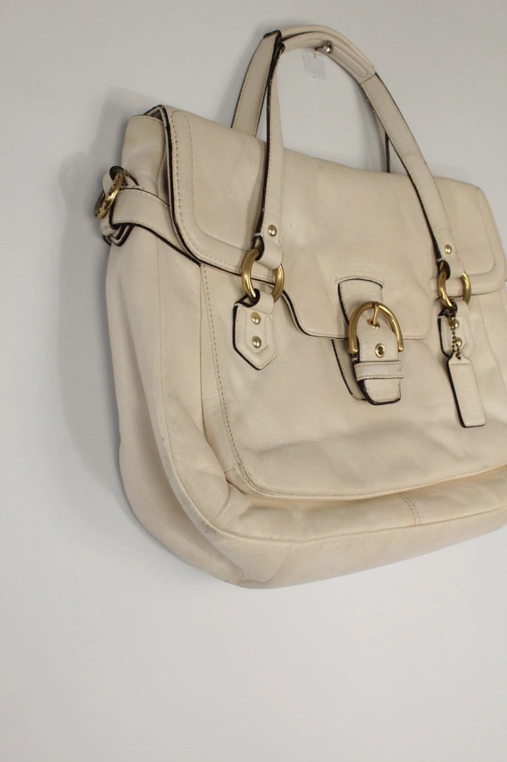 Coach cream leather satchel bag with gold-tone buckle clasp and matching hangtag.