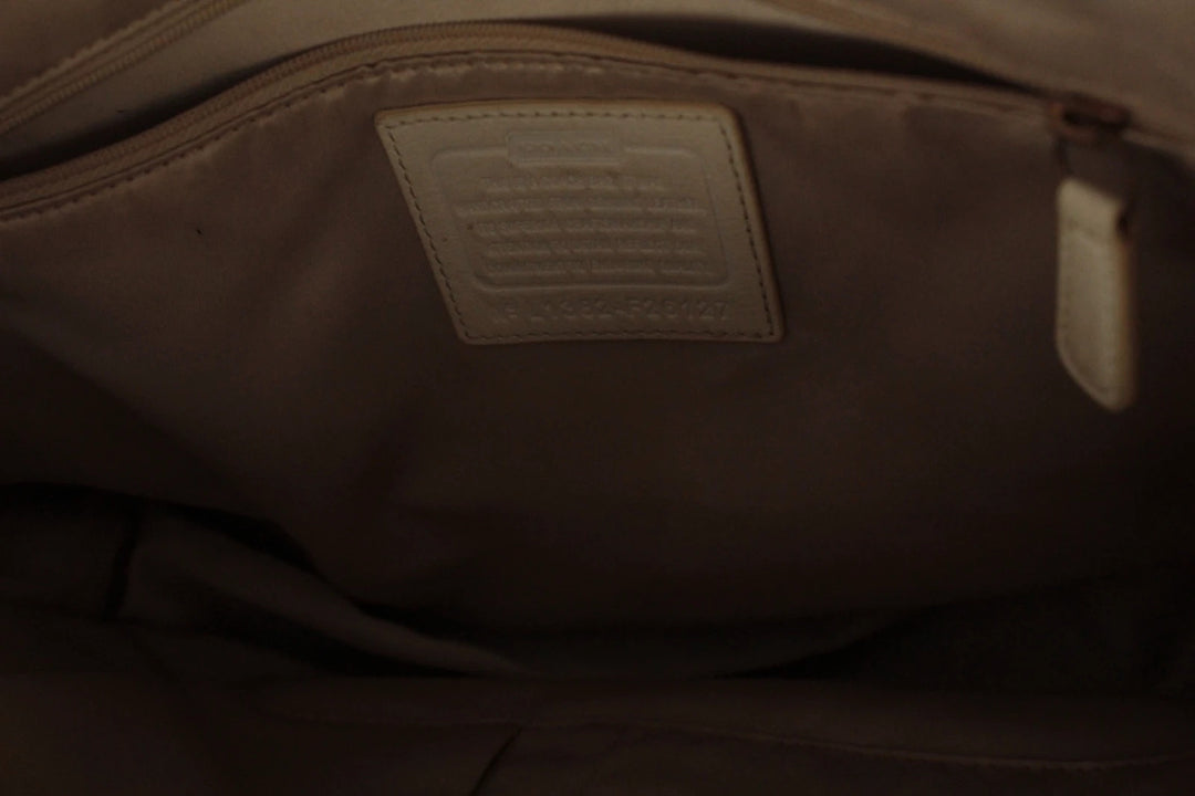 Coach cream leather satchel bag with gold-tone buckle clasp and matching hangtag.