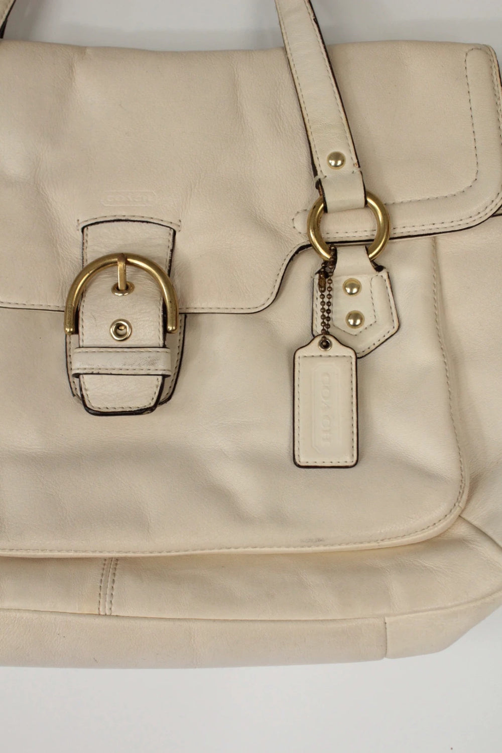Coach cream leather satchel bag with gold-tone buckle clasp and matching hangtag.