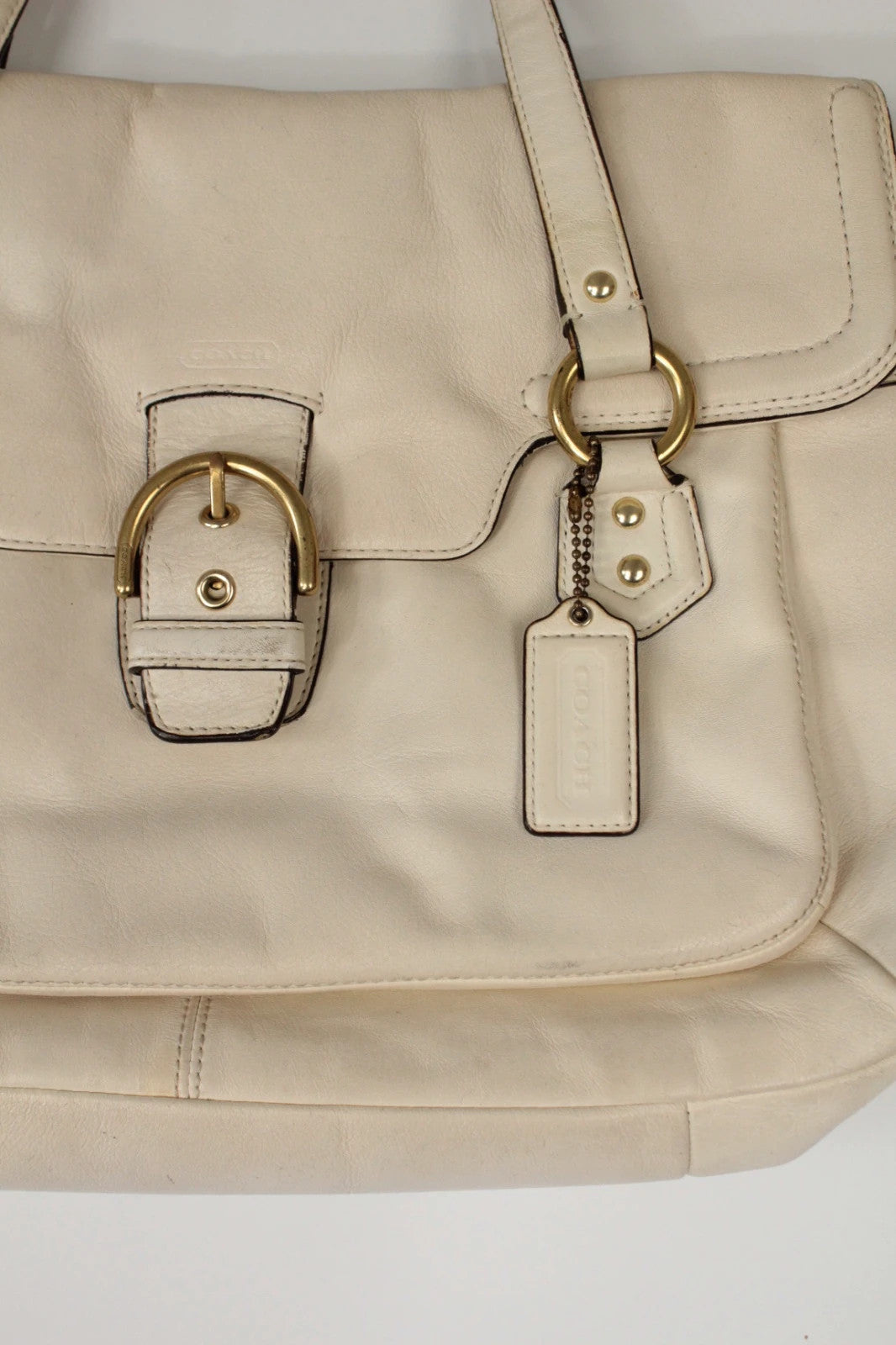 Coach cream leather satchel bag with gold-tone buckle clasp and matching hangtag.