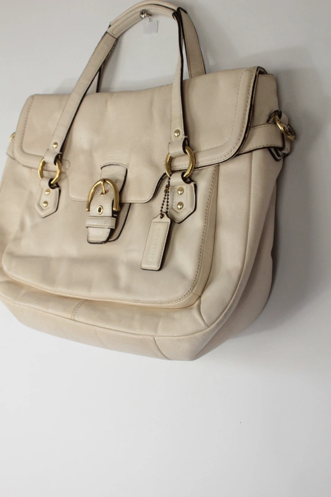 Coach cream leather satchel bag with gold-tone buckle clasp and matching hangtag.