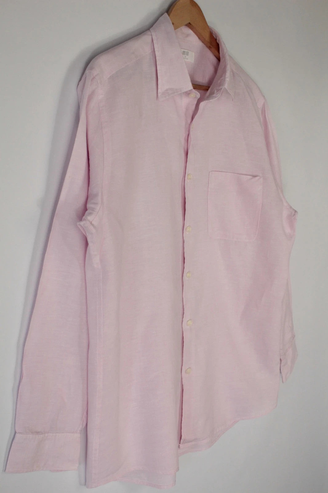 Uniqlo light pink long sleeve linen shirt with classic white buttons and chest pocket.