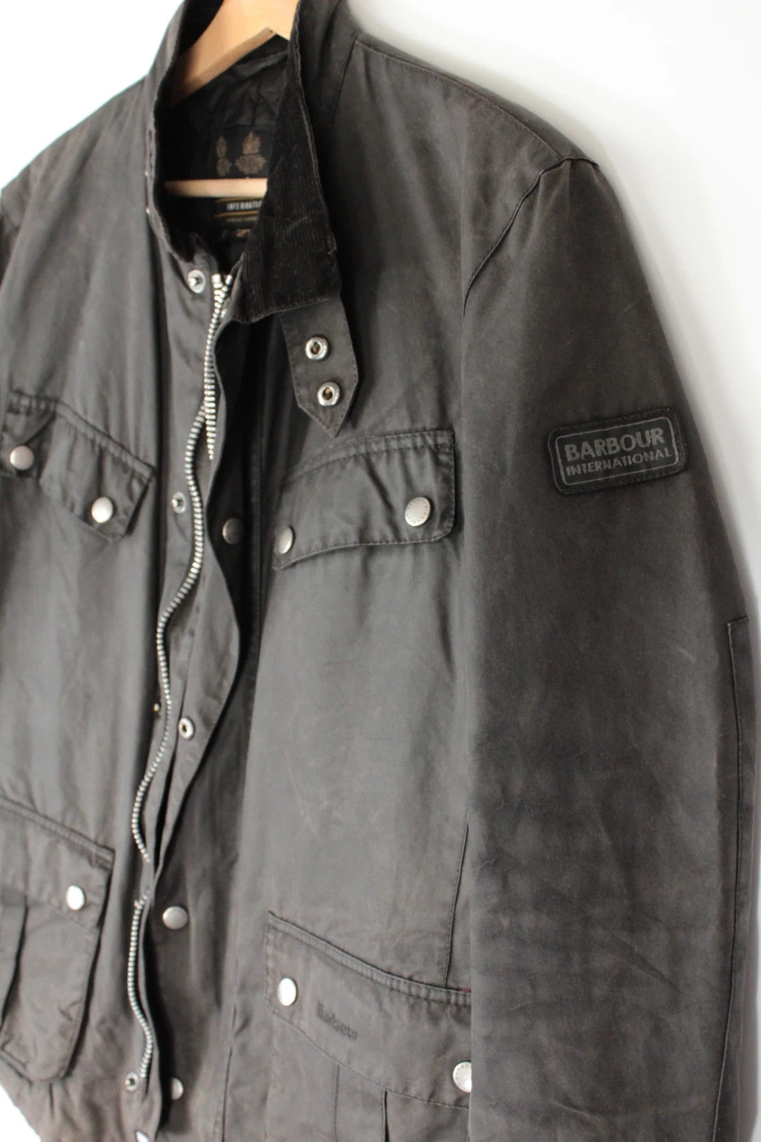 Barbour black waxed cotton motorcycle jacket with corduroy trim and vintage patina.
