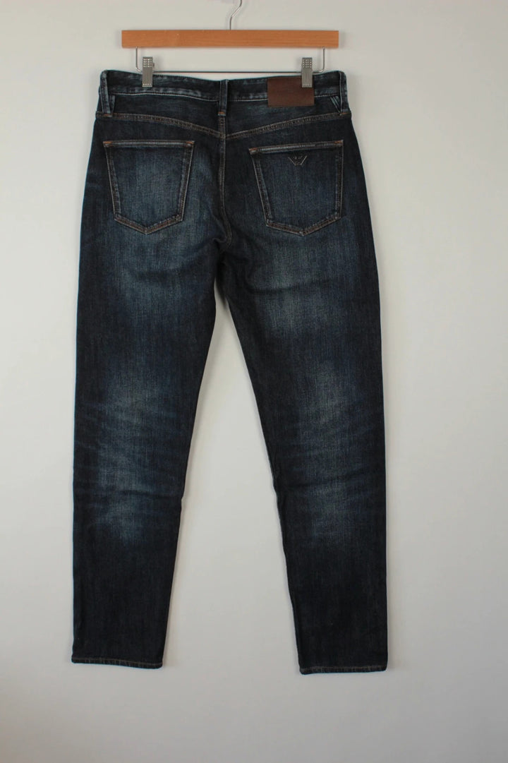 Emporio Armani navy slim jeans with metal eagle logo and leather waist patch.
