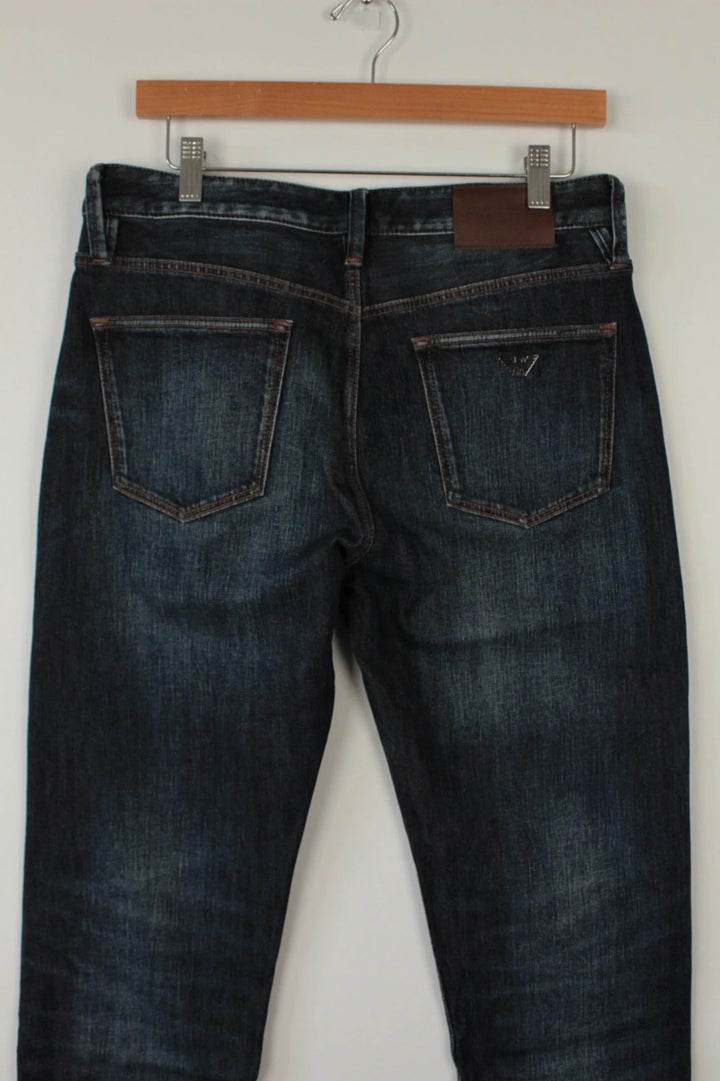 Emporio Armani navy slim jeans with metal eagle logo and leather waist patch.
