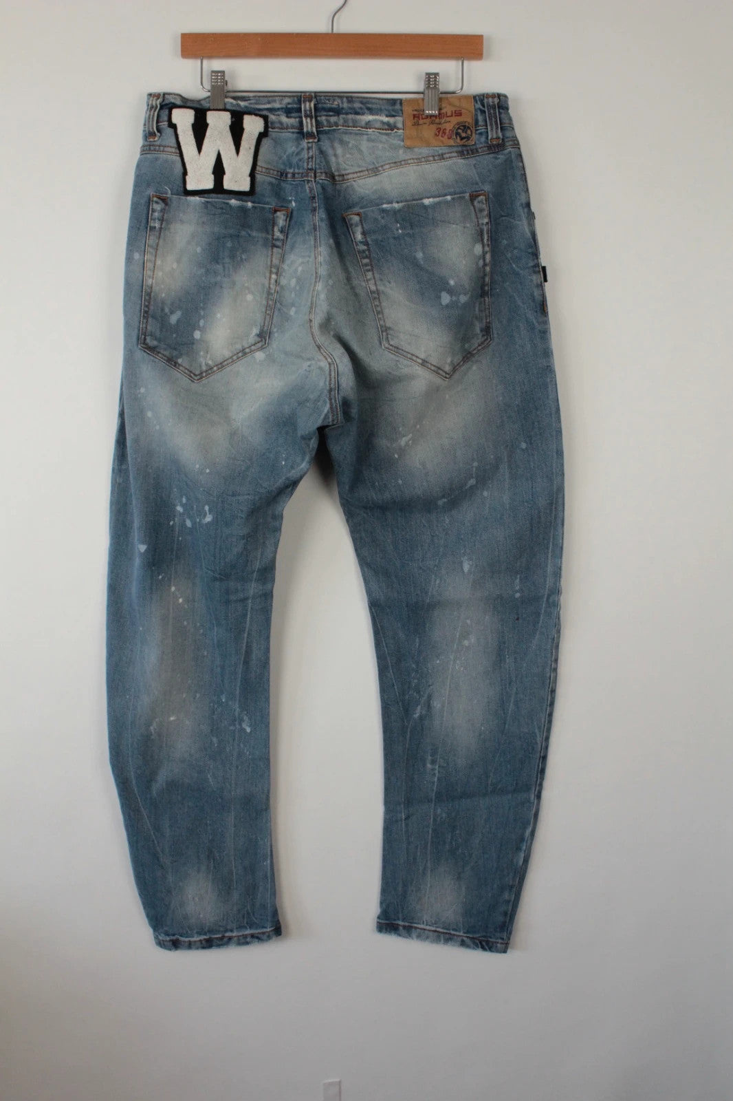 Adamus baggy jeans black and blue with bleach paint splatter and tan leather waistband patch.