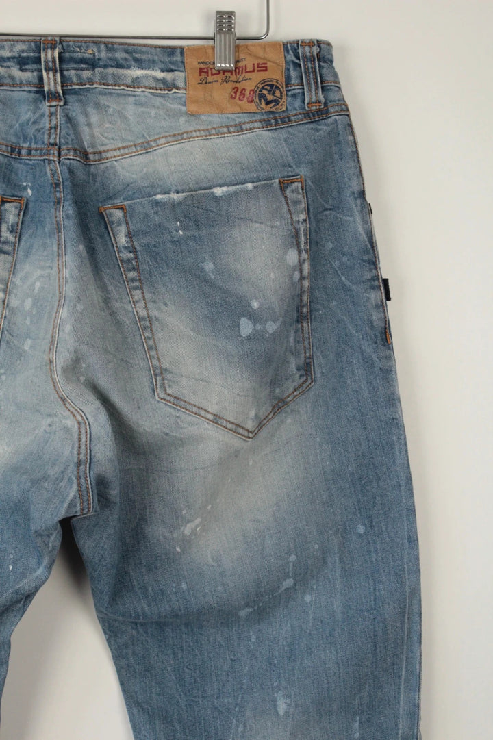 Adamus baggy jeans black and blue with bleach paint splatter and tan leather waistband patch.