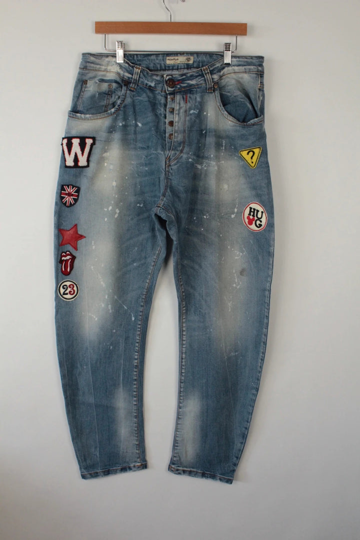 Adamus baggy jeans black and blue with bleach paint splatter and tan leather waistband patch.