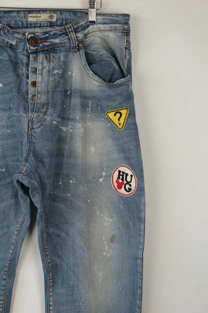 Adamus baggy jeans black and blue with bleach paint splatter and tan leather waistband patch.