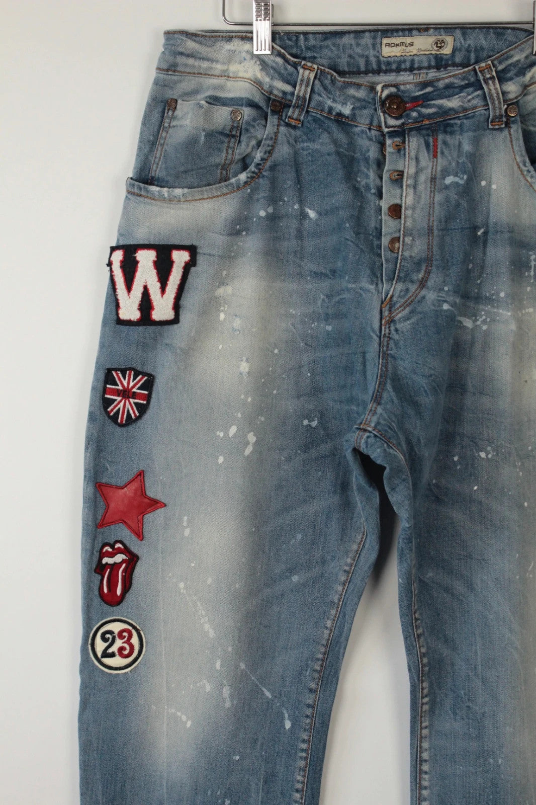 Adamus baggy jeans black and blue with bleach paint splatter and tan leather waistband patch.