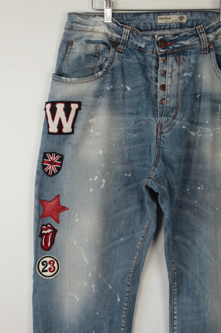 Adamus baggy jeans black and blue with bleach paint splatter and tan leather waistband patch.